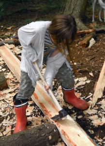 Child trying Hewing timber with an adze