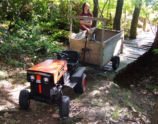 Mini Tractor and trailer crossing bridge in woodland